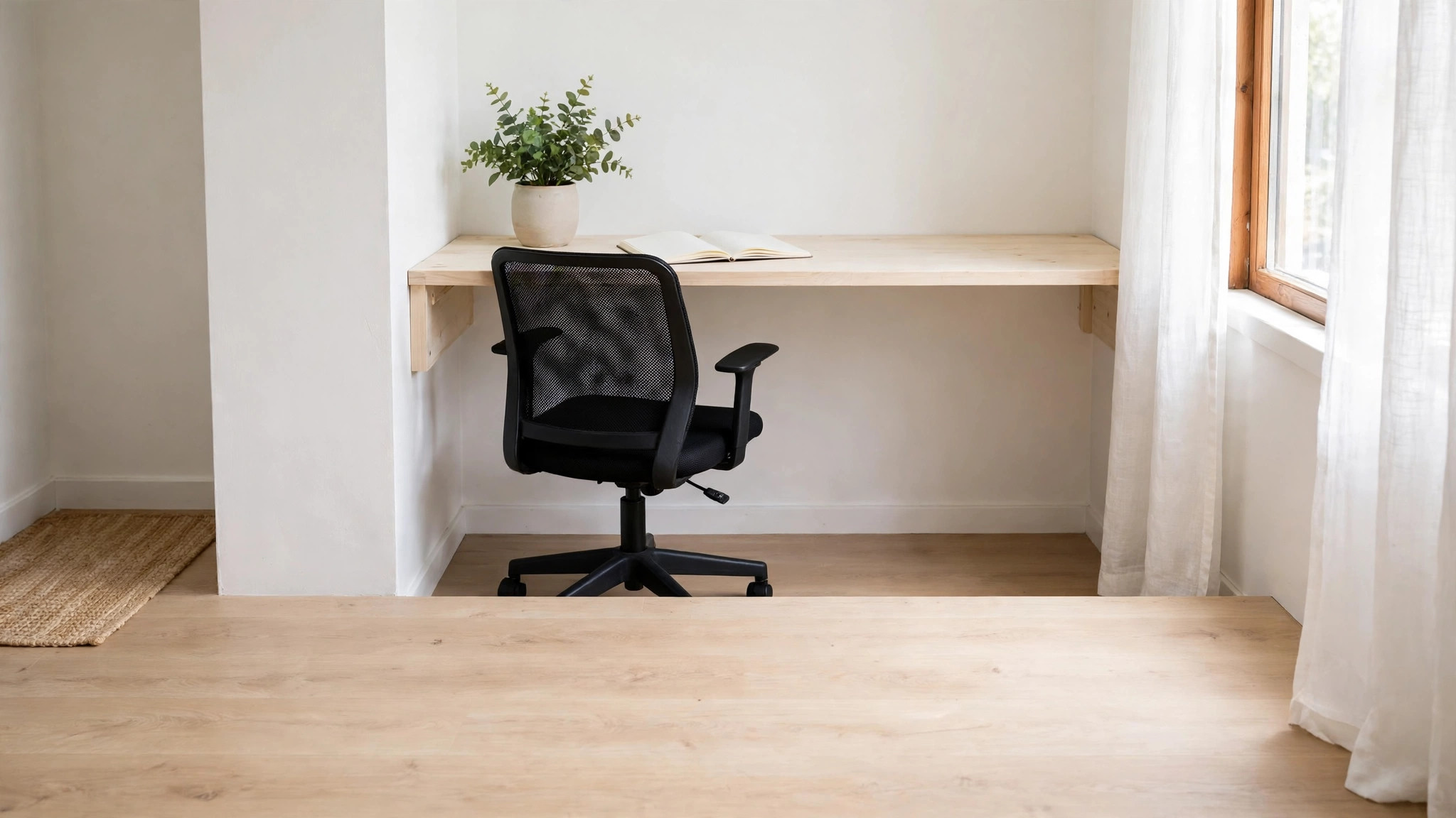 Tiny-room setup mockup with a compact mesh chair tucked under a wall desk